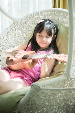 Little girl playing ukulele
