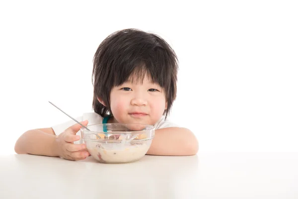 Liten asiatisk pojke äter frukost på bordet — Stockfoto