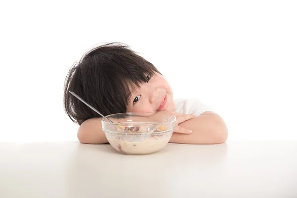 Liten asiatisk pojke äter frukost på bordet — Stockfoto