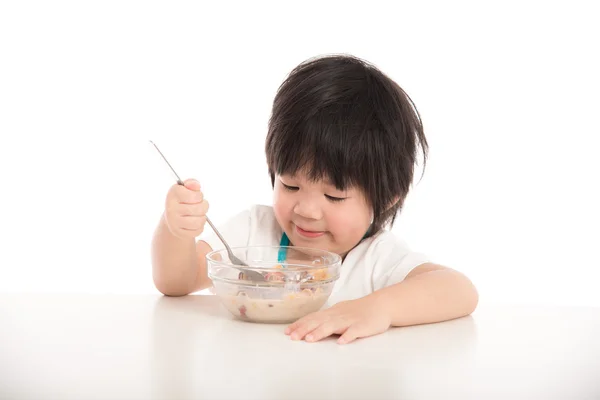 Liten asiatisk pojke äter frukost på bordet — Stockfoto