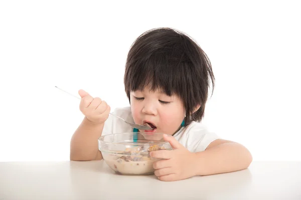 Little asian boy eating breakfast on table — Stock Photo, Image