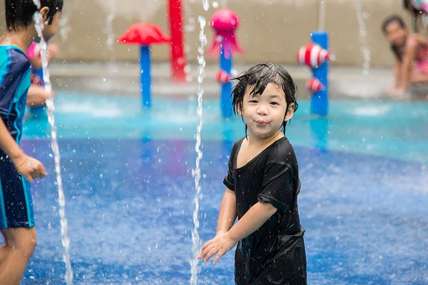 Heureux asiatique garçon a amusant jouer dans eau fontaines — Photo