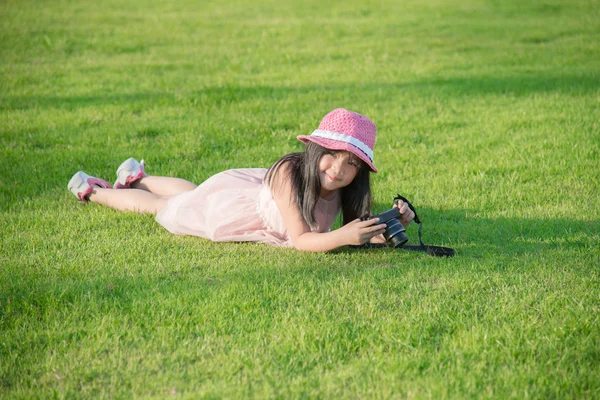 Mooie Aziatische meisje liegen en vasthouden van camera — Stockfoto
