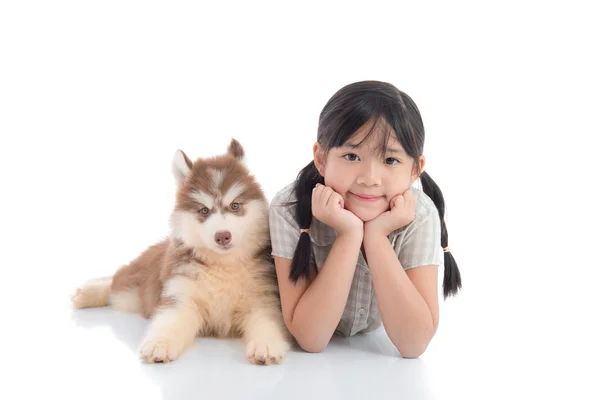 Bela ásia menina e siberiano husky filhote de cachorro deitado no branco ba — Fotografia de Stock