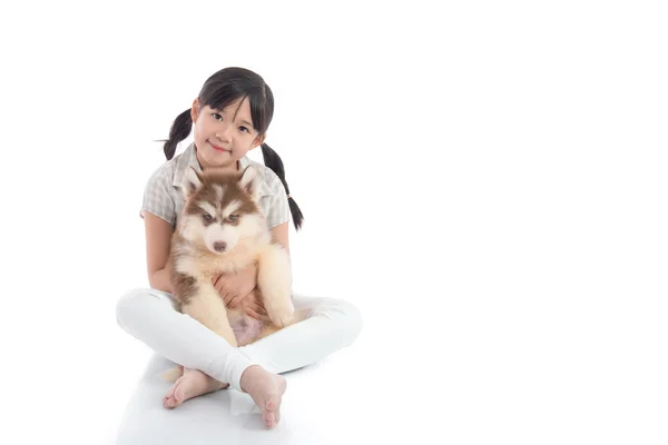 Mooie Aziatische meisje knuffelen Siberische husky pup op witte backg — Stockfoto