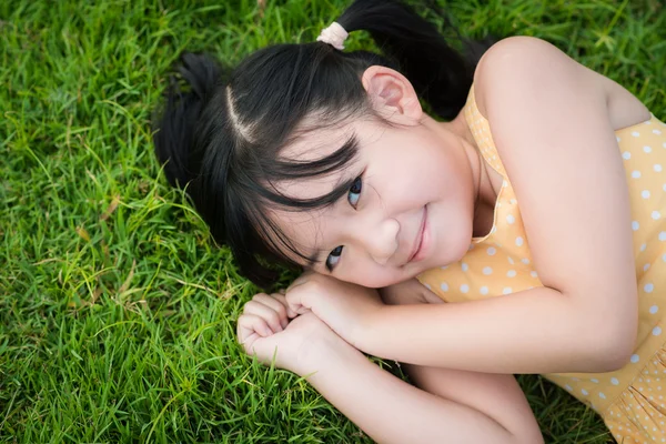 Retrato de menina asiática feliz deitado — Fotografia de Stock