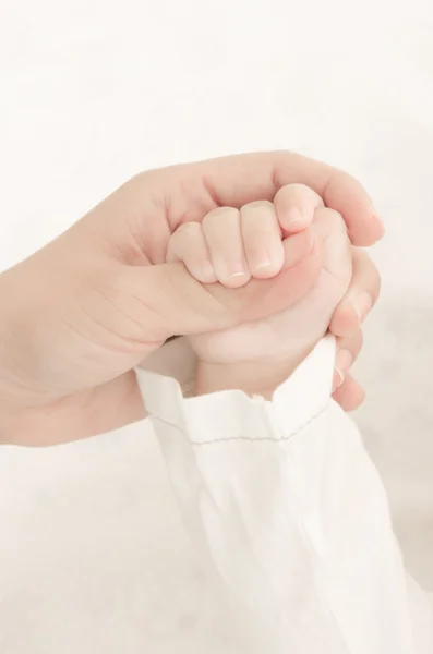 Mani di madre che tiene la mano del bambino — Foto Stock