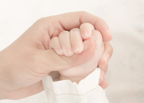 Mani di madre che tiene la mano del bambino — Foto Stock