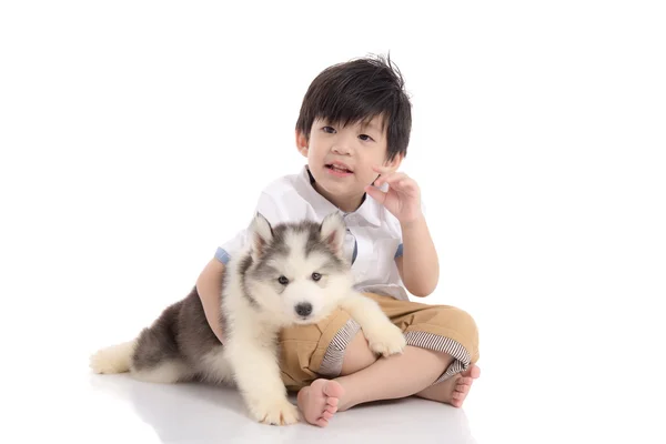 Lindo asiático chico sentado con siberiano husky cachorro — Foto de Stock