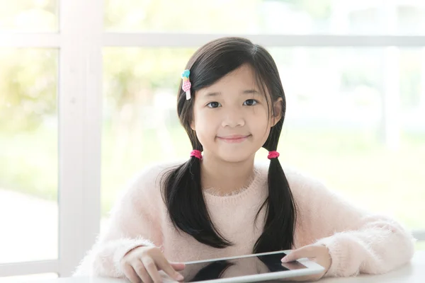 Menina asiática bonita usando tabela — Fotografia de Stock