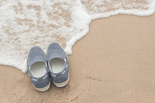 Zapatos de lona en playa de arena — Foto de Stock