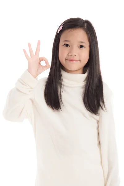 Симпатична азіатська дівчина в білій сукні з черепашкою, що показує знак ОК — стокове фото