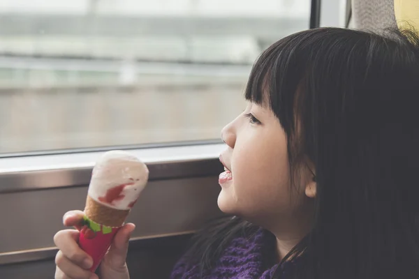 Little asian girl smiling  and eating ice cream — Stock Photo, Image