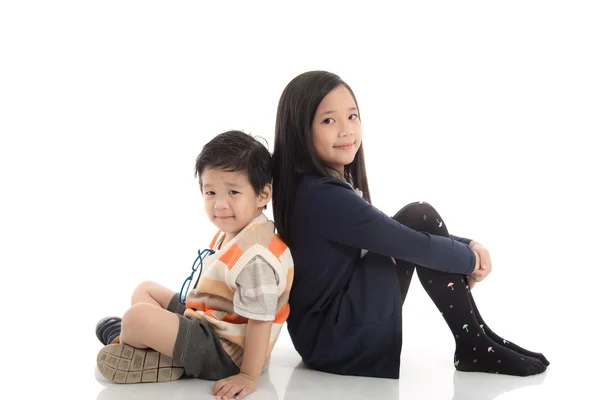 Dwa szczęśliwy azjatyckich dzieci siedzi i opierając się na każdego othe — Zdjęcie stockowe