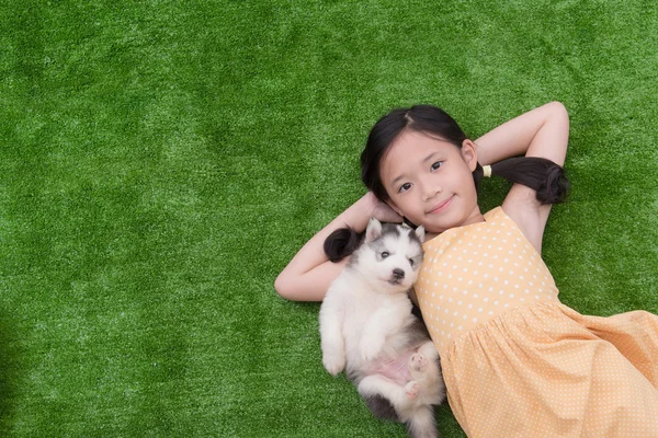 Bonito ásia menina mentira com ela filhote de cachorro — Fotografia de Stock