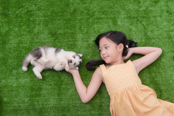 Bonito ásia menina mentira com ela filhote de cachorro — Fotografia de Stock
