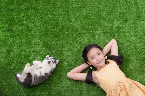 Bonito ásia menina mentira com ela filhote de cachorro — Fotografia de Stock