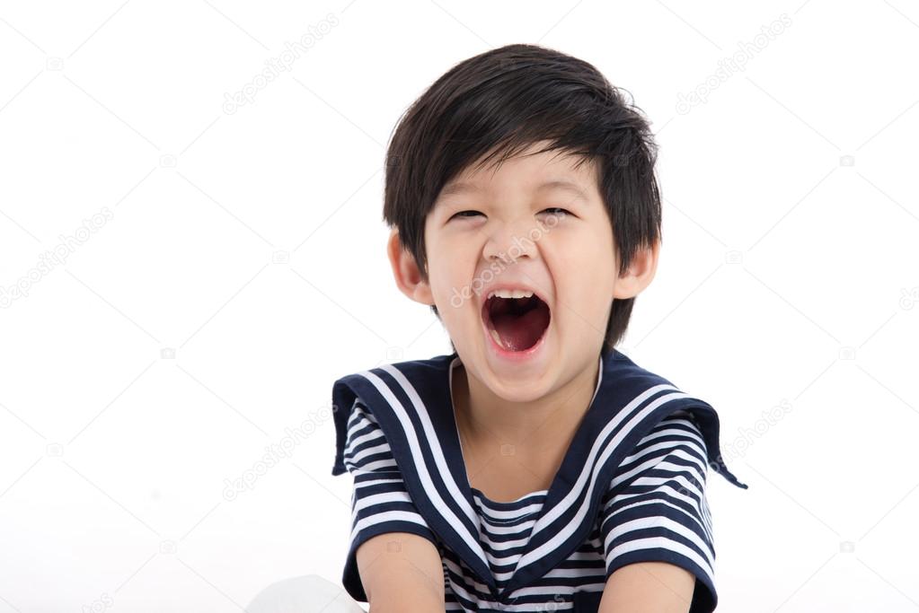 Happy asian boy sitting on white background