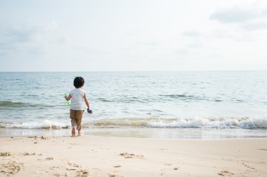 Asyalı çocuk kumsalda oynarken