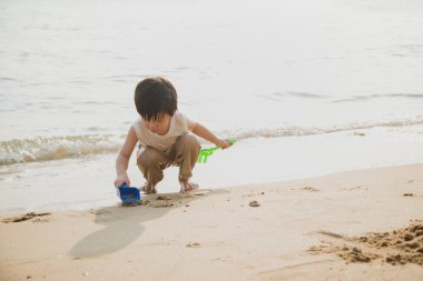 Asyalı çocuk kumsalda oynarken