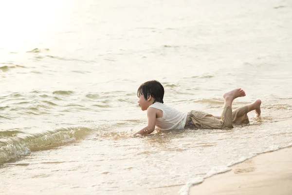 Söta asiatiska pojken spelar på stranden — Stockfoto