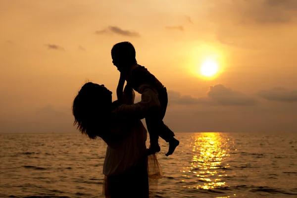 Mãe e filho brincando na praia na madrugada — Fotografia de Stock