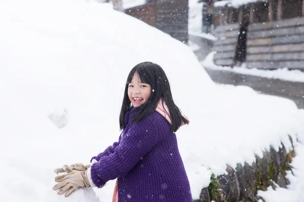 Мила азіатська дівчина посміхається на відкритому повітрі в снігу — стокове фото
