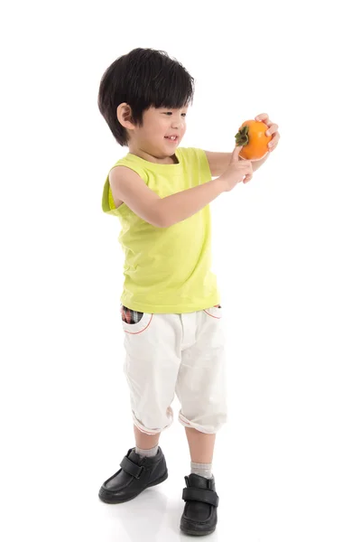 Söta asiatiska pojken anläggning persimon — Stockfoto