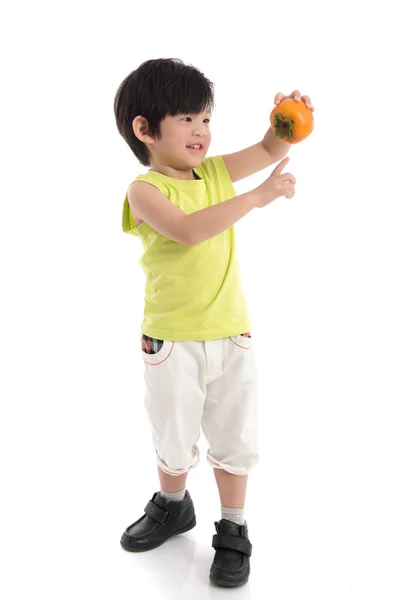 Cute asian boy holding persimmon — Stock Photo, Image