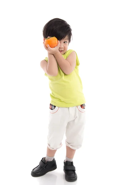 Cute asian boy holding persimmon — Stock Photo, Image