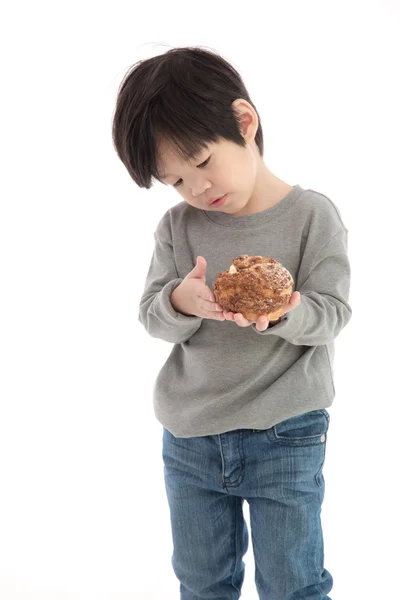 Cute asian boy eating cream puff — Stock Photo, Image