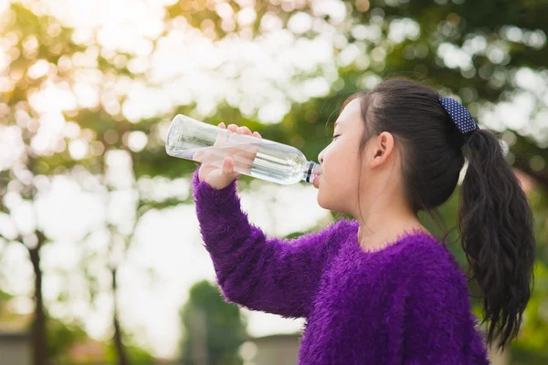 Gyönyörű ázsiai lány iszik víz egy üveg — Stock Fotó