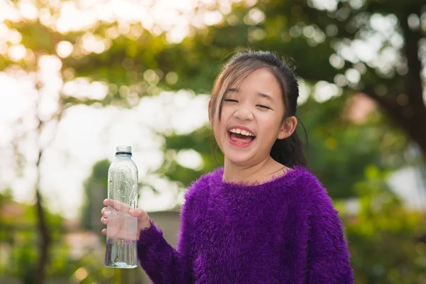 Mooie Aziatische meisje drinkt water uit een fles — Stockfoto