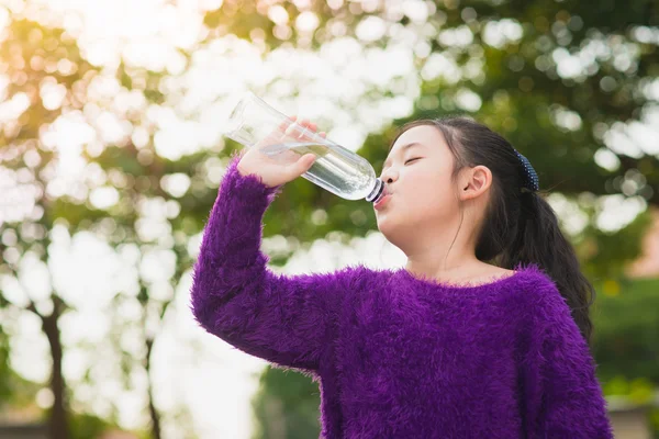 Vacker asiatisk tjej dricker vatten ur en flaska — Stockfoto