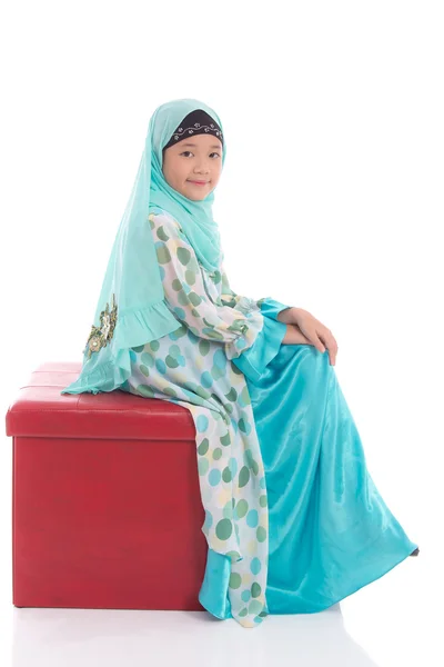 赤いスツールに座っているアジアのイスラム教徒の少女 — ストック写真