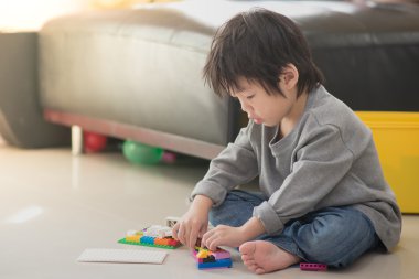 Asyalı çocuk renkli inşaat bloklarla oynama 