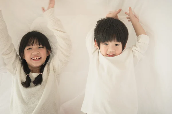 Lindo asiático niños jugando en cama —  Fotos de Stock