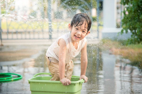 Menino se diverte brincando na água — Fotografia de Stock