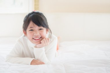 Asyalı kız yatakta yatıyordu