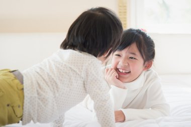 Asya çocuk beyaz yatakta yatarken