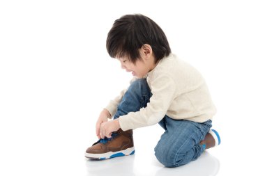 İzole kırmızı taburede oturan sevimli Asya çocuk