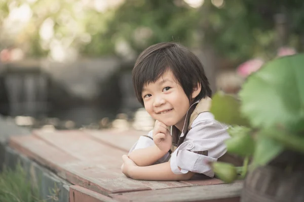 Милый азиатский мальчик лежит в саду — стоковое фото