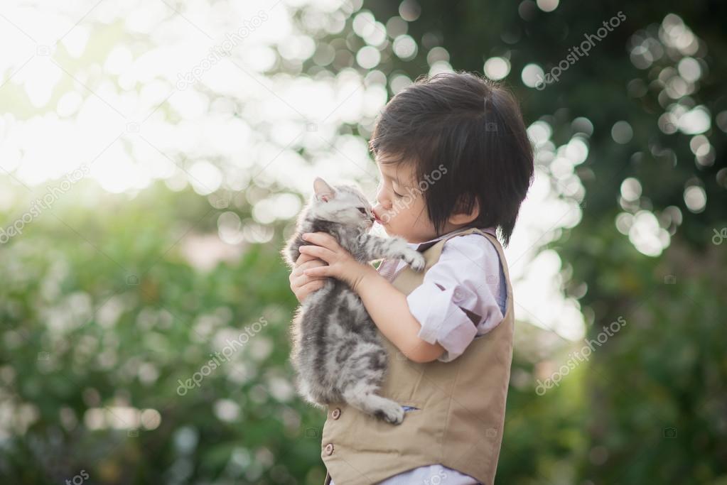 Asian boy  kissing american short hair  kitten 