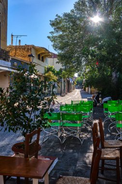 Early morning in empty narrow streets of old mediterranean town. Bright sunlight. Street cafe furniture in foreground. Chania, Crete, Greece