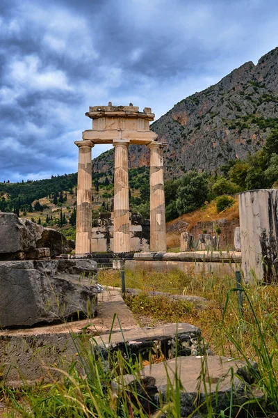Pionowy widok ruin Tholos starożytnej greckiej bogini Athena Pronaia w Delphi, Grecja. Kolumny doryckie. Góra Parnassos. Lista światowego dziedzictwa UNESCO. — Zdjęcie stockowe