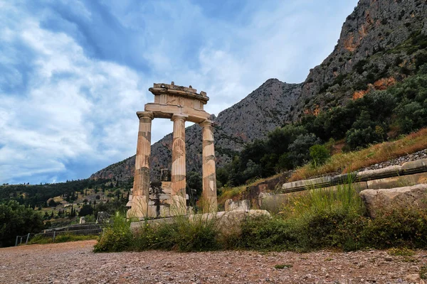 Ruiny Tholos starożytnej greckiej bogini Ateny Pronai w Delphi, Grecja. Trzy kolumny doryckie na świętej górze Parnassos. Lista światowego dziedzictwa UNESCO. — Zdjęcie stockowe
