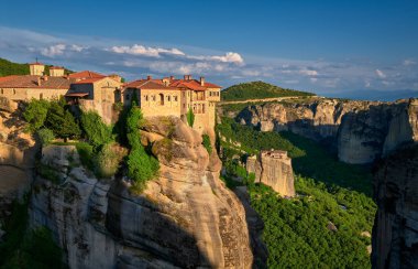 Uçurumun tepesindeki Varlaam manastırı, akşam güneşi, Meteora, Yunanistan, tipik kaya manzarası. Moni Agias Varvaras Roussanou manastırı. UNESCO Dünya Mirası
