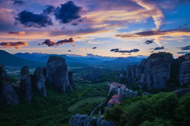 Meteora Vadisi 'nin alacakaranlık manzarası. Moni Agias Varvaras Roussanou manastırı, kayalar, kayalıklar. Güzel gökyüzü, renkli bulutlar. Yunanistan ve UNESCO Dünya Mirası