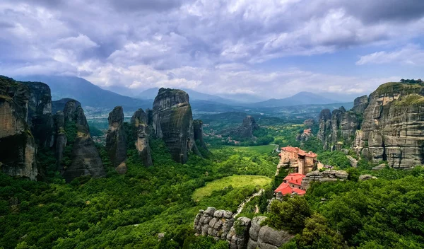 Pohled na klášter Moni Agias Varvaras Roussanou, skály Meteory, Řecka a údolí. Světové dědictví UNESCO. Obloha zatažená, sluneční paprsky dopadají na klášter — Stock fotografie