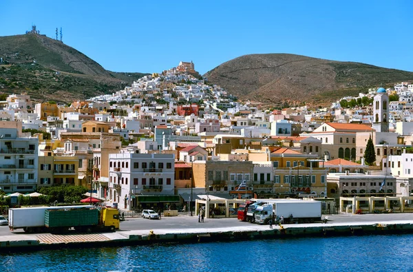Ville d'Ano Syros, île de Syros, Grèce, cathédrale catholique St George ci-dessus, maisons colorées, soleil d'été, camions dans le port d'Ermoupoli, mer Méditerranée. — Photo